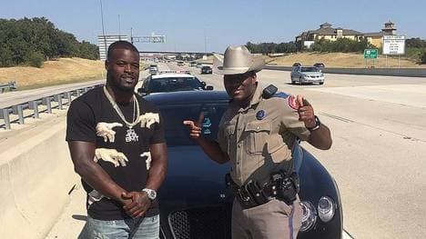 Ein Polizist posiert mit Cowboys-Running-Back Christine Michael