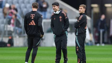 Aleksander Pavlovic (M.) und Joshua Kimmich (r.) spielen beim FC Bayern im zentralen Mittelfeld