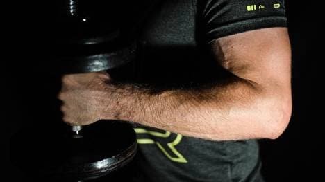 Ein Mann führt Hammer Curls durch um seinen Bizeps zu trainieren