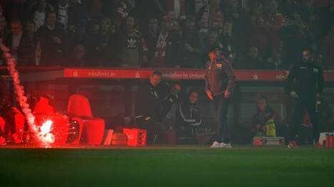 Eine Leuchtrakete schlägt neben der Bank von Union Berlin ein