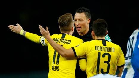 Marco Reus (l.) und Raphael Guerreiro diskutieren mit Schiedsrichter Sven Jablonski