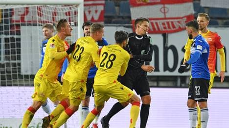 Die Spieler von Union Berlin reklamieren bei Schiedsrichter Tobias Reichel (3.v.r.), den letzten Schuss noch als Treffer anzuerkennen