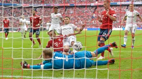 Manuel Neuer (in blau) pariert den Nachschuss von Kevin Volland (in weiß, Mitte). Kurz darauf muss er die Wiederholung des Elfmeters von Wendell passieren lassen 