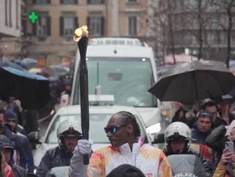 Der US-Rapper Snoop Dogg wurde eingeladen, die olympische Fackel im Vorfeld der Winterspiele 2026 durch die Straßen Italiens zu tragen. Dabei wird er von Dutzenden begeisterten Fans begleitet.