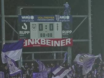 Das Drittliga-Spiel zwischen dem SSV Ulm 1846 und dem VfL Osnabrück kann erst mit Verzögerung beginnen, weil ein Gästefan auf die Anzeigetafel klettert. Die Kommentatoren sind fassungslos.