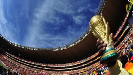 A fan holds a replica Jules Rimet World