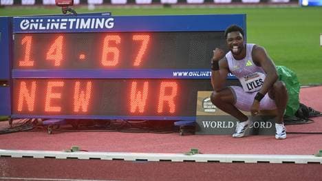 Noah Lyles posiert neben dem Weltrekord über 150 Meter