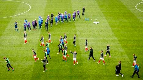 Die dänischen und finnischen Spieler kehren nach rund eineinhalbstündiger Unterbrechung auf den Platz zurück