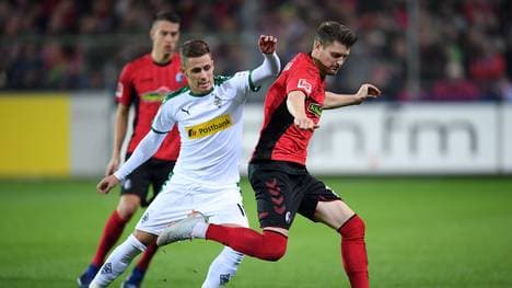 Lukas Kübler von Freiburg im Zweikampf mit Thorgan Hazard