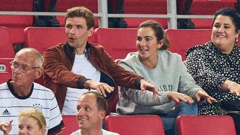 Thomas Müller und seine Frau Lisa machen die La-Ola-Welle in der Allianz Arena